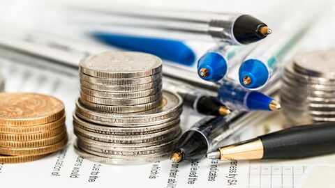 Versicherung Geld und Stifte liegen auf Dokumenten