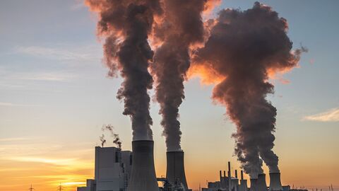 Treibhausgae Abgase steigen aus einem Kraftwerk in den Himmel