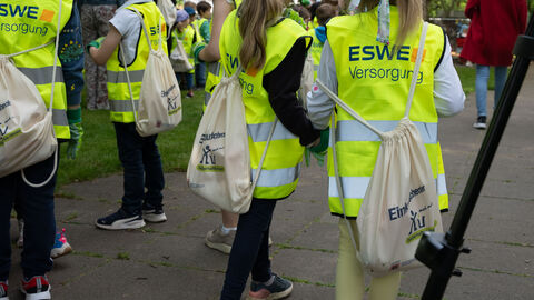 Kinder tragen glebe Warnwesten und Beutel mit dem Aufdruck Sauberhaftes Hessen