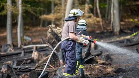 Einsatz im Wald Ein Feuerwehrmann löscht einen Brand im Wald