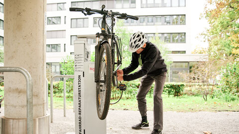 Fahrradfreundlicher Arbeitgeber Ein Mann repariert sein Fahrrad