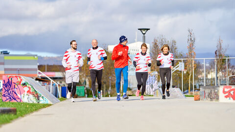 Laufgruppe im HMUKLV Fünf Personen joggen auf einem asphaltiertem Weg