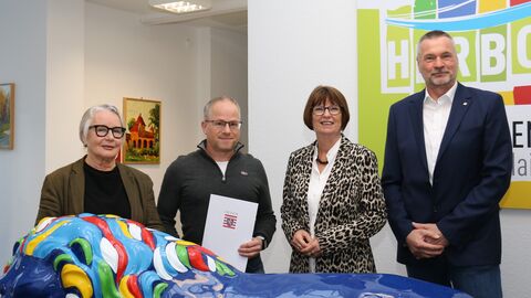 Vier Personen stehen nebeneinander. 