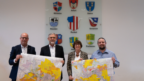 Übergabe der Fließpfadkarten in Runkel Drei Männer und eine Frau halten Stadtkarten in den Händen