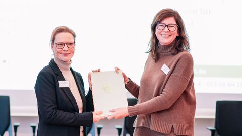 Zwei Frauen halten eine Urkunde in der Hand