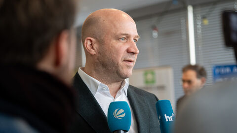 Minister Jung beim O-Ton Ein Mann spricht in zwei Mikrofone