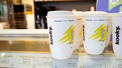 Mehrere Mehrwegbecher auf Verkaufstresen. 