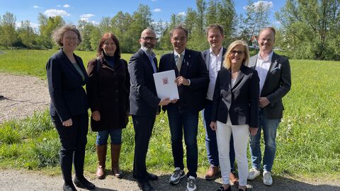 Fünf Personen in der Natur mit Förderbescheid