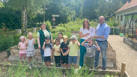 In Begleitung von Kindern der Kita Gräselberg und Annette Stosius, pädagogische Mitarbeiterin der Fasanerie (l.), überreicht Umweltminister Ingmar Jung der Wiesbadener Bürgermeisterin Christiane Hinninger den Förderbescheid von über 27.500 Euro an das Naturpädagogische Zentrum der Fasanerie, das die BNE-Angebote in Wiesbaden koordiniert.