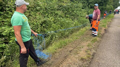 Zwei Personen beim Errichten eines Wildschutzzauns.