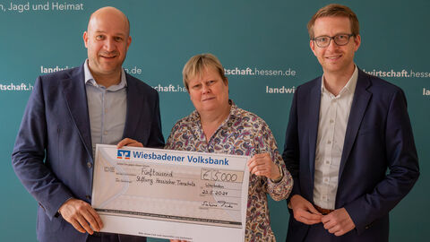 Prof. Dr. Sabine Tacke überreichteinen Spendenscheck an Ingmar Jung im Beisein von Michael Ruhl