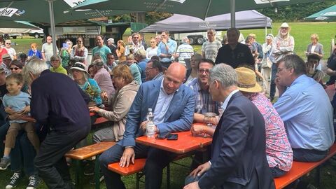 Heimatminister Jung sitzt als Gast beim Festival „Blues, Schmus, Apfelmus“ in Laubach zwischen den Zuschauern.
