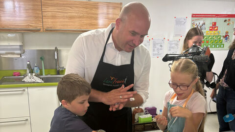 Ingmar Jung beim Kinder-Kochkurs „Cool kochen in den Ferien“ des Landfrauenverbandes in Oberursel. Ingmar Jung kocht zusammen mit zwei Kindern.