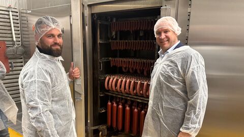 Landwirtschaftsminister Ingmar Jung (rechts) zusammen mit Dennis Rossmann an einem Räucherschrank.