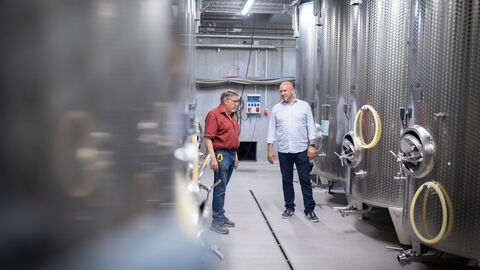 Weinbauminister Ingmar Jung zu Besuch im Weingut Diefenhardt beim Rheingauer Weinbaupräsidenten Peter Seyffardt. Ingmar Jung und Peter Seyffardt zwischen großen Weintanks.
