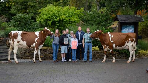 Landwirtschaftsminister Ingmar Jung mit Familie Biederbick und zwei Kühen.