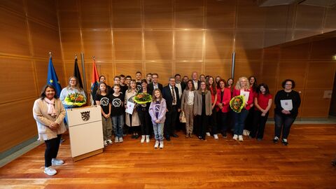 Ein Gruppenbild mit vielen Menschen, die in die Kamera schauen.